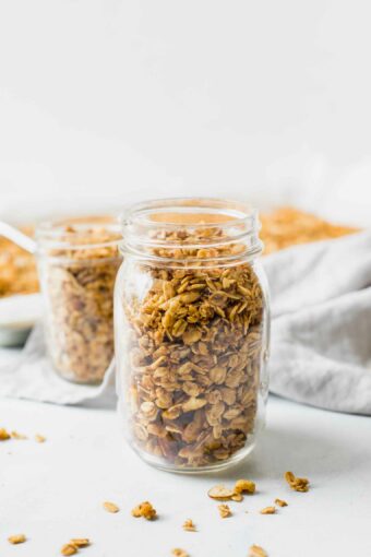Healthy Homemade Granola in a mason jar with a grey napkin in the background.