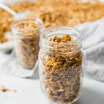 Close up of healthy granola in a mason jar with a napkin in the background.