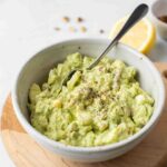 Healthy Avocado Egg Salad in a white bowl with a spoon.