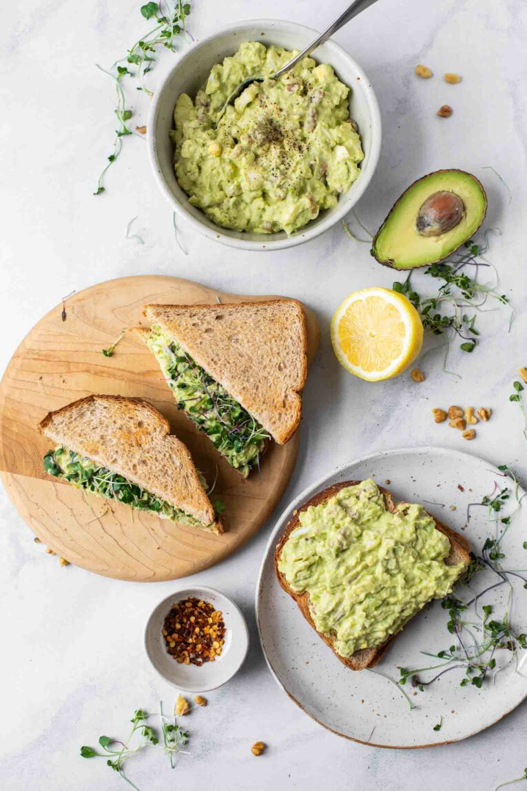 Top shot of avocado egg salad in a bowl and on bread for sandwiches.