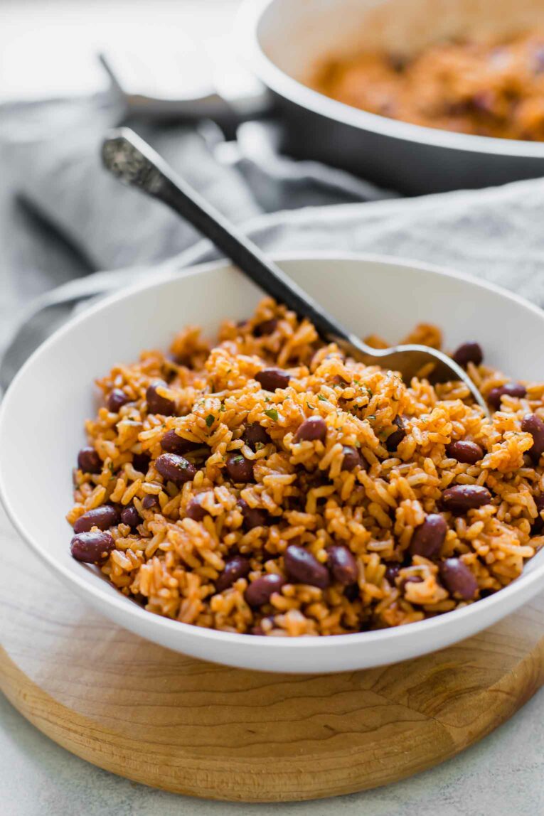 Rice and beans in a white bowl with a spoon.