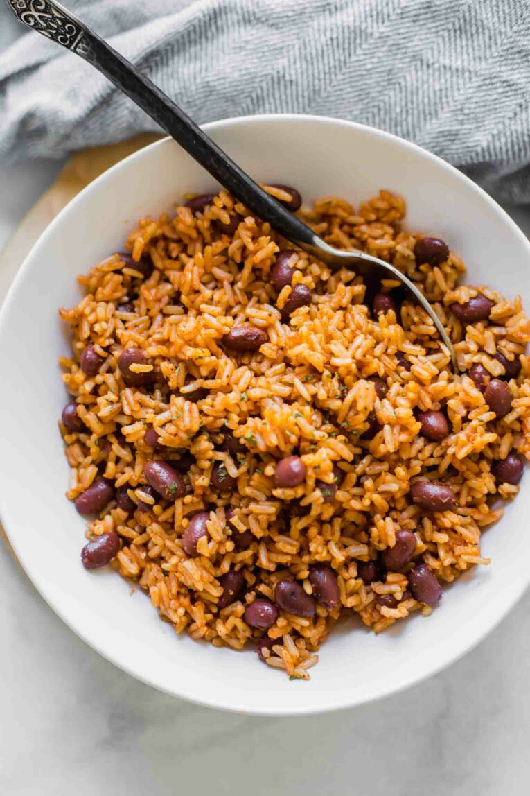 Top shot of Spanish Rice & Beans in a white bowl with a spoon.