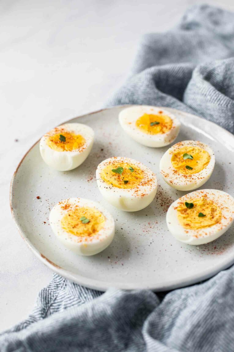 Angled shot of hard boiled eggs on a grey plate.