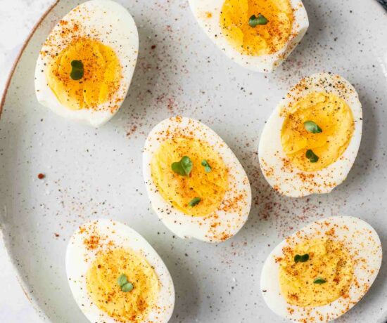 Close up of hard boiled eggs topped with salt, pepper, and paprika.