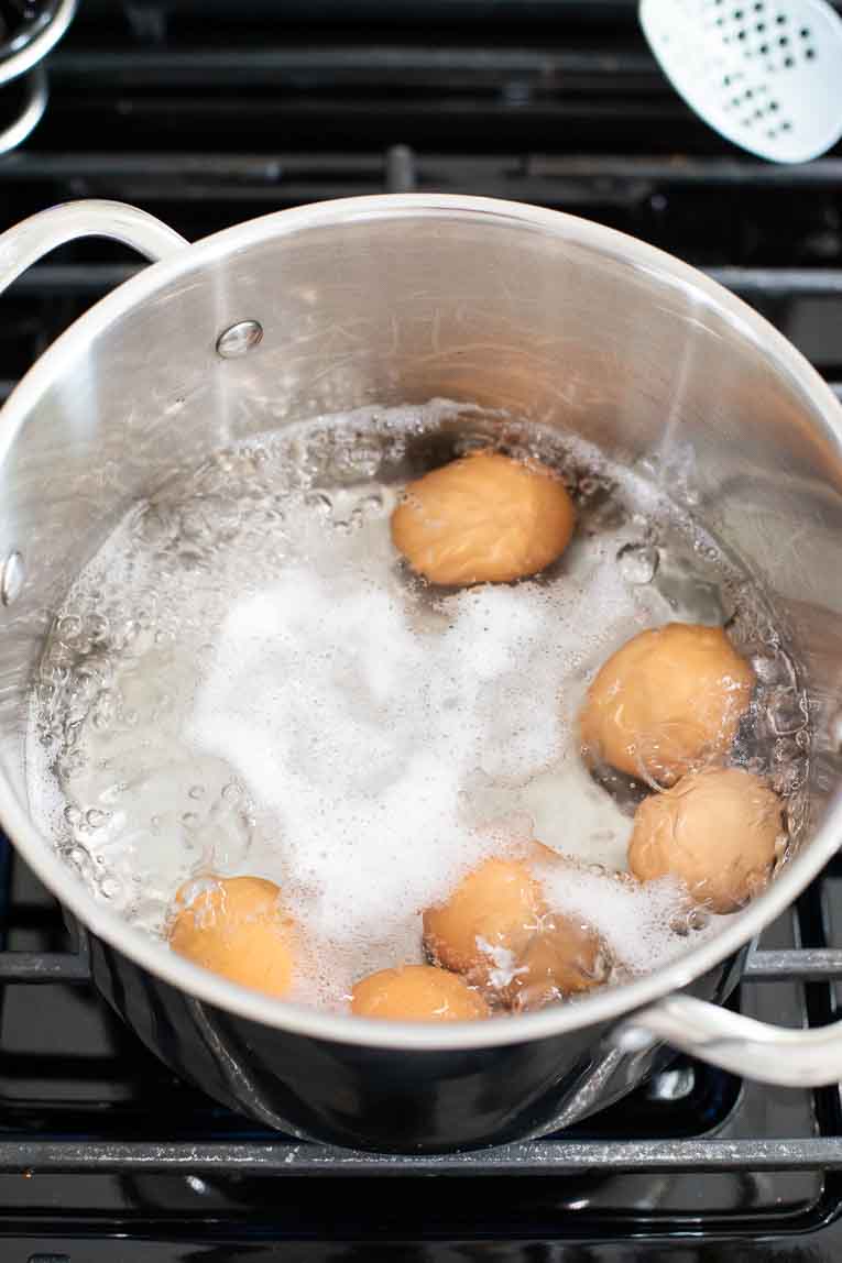 Eggs in boiling water in a stock pot.