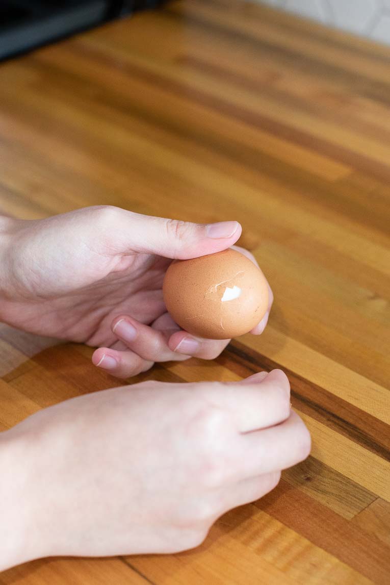 Egg being peeled for hard boiled eggs.