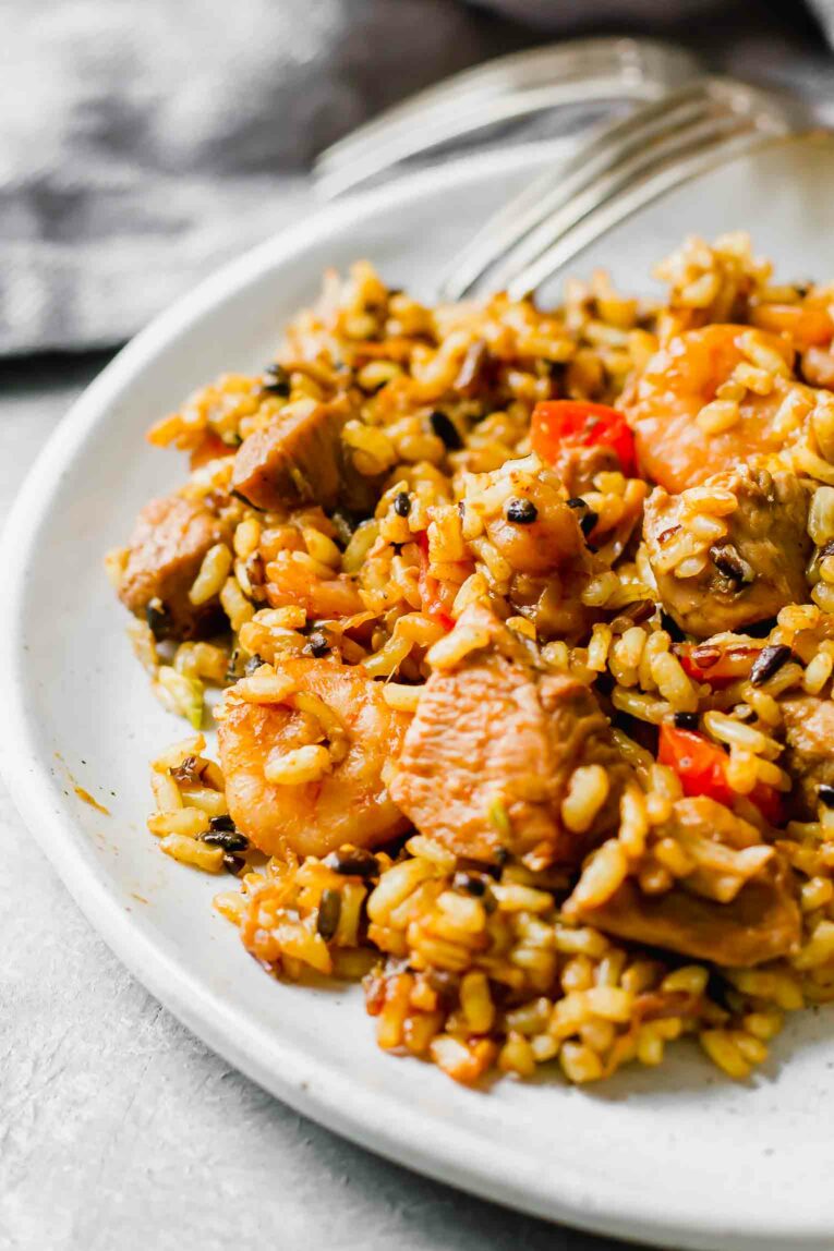 Close up of Chicken & Shrimp Spanish Paella on a white plate.