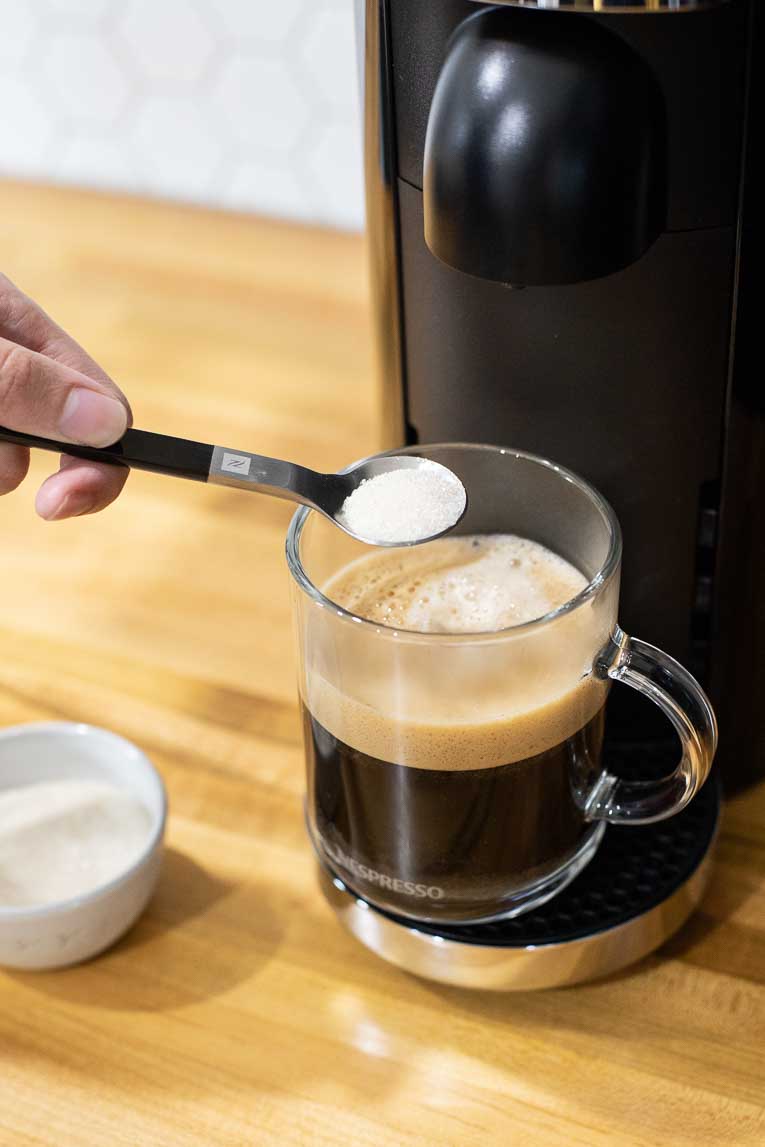 Pouring sugar into freshly brewed coffee.