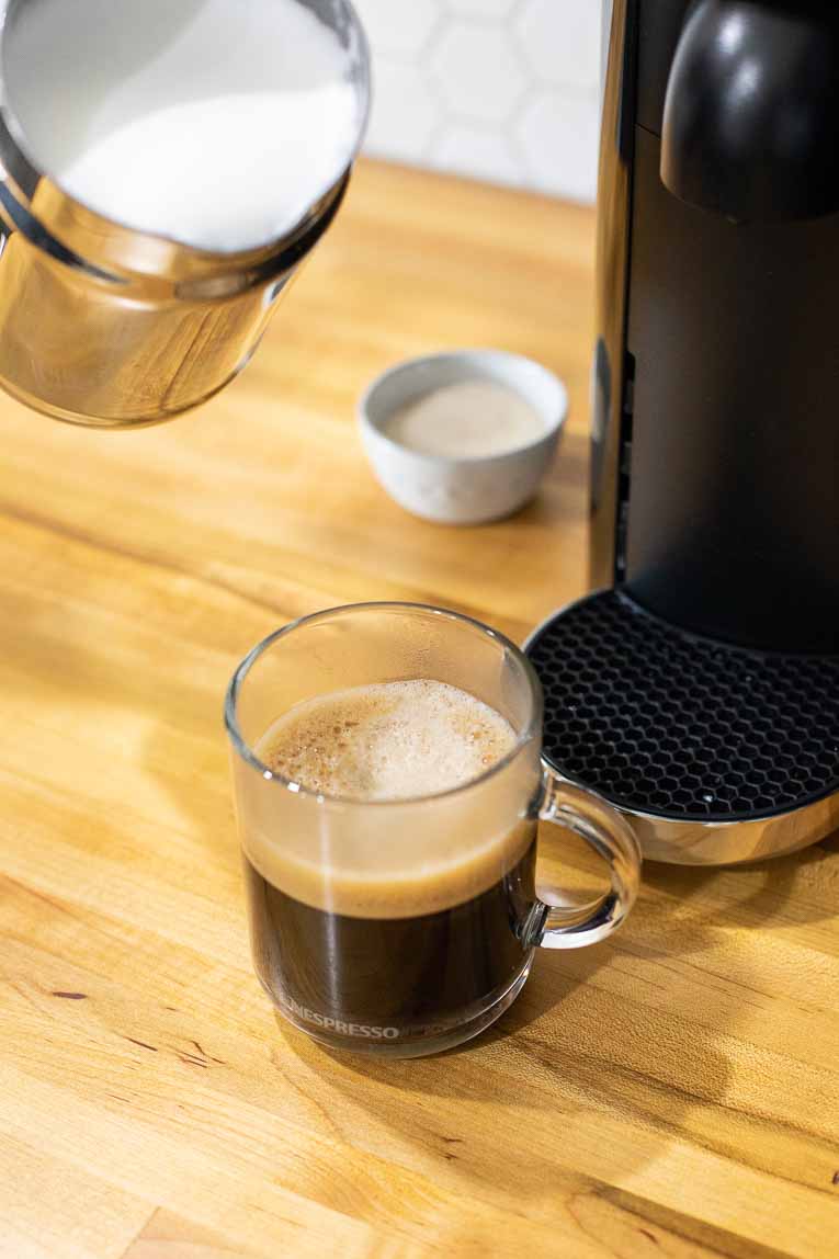 Pouring milk into freshly brewed coffee.
