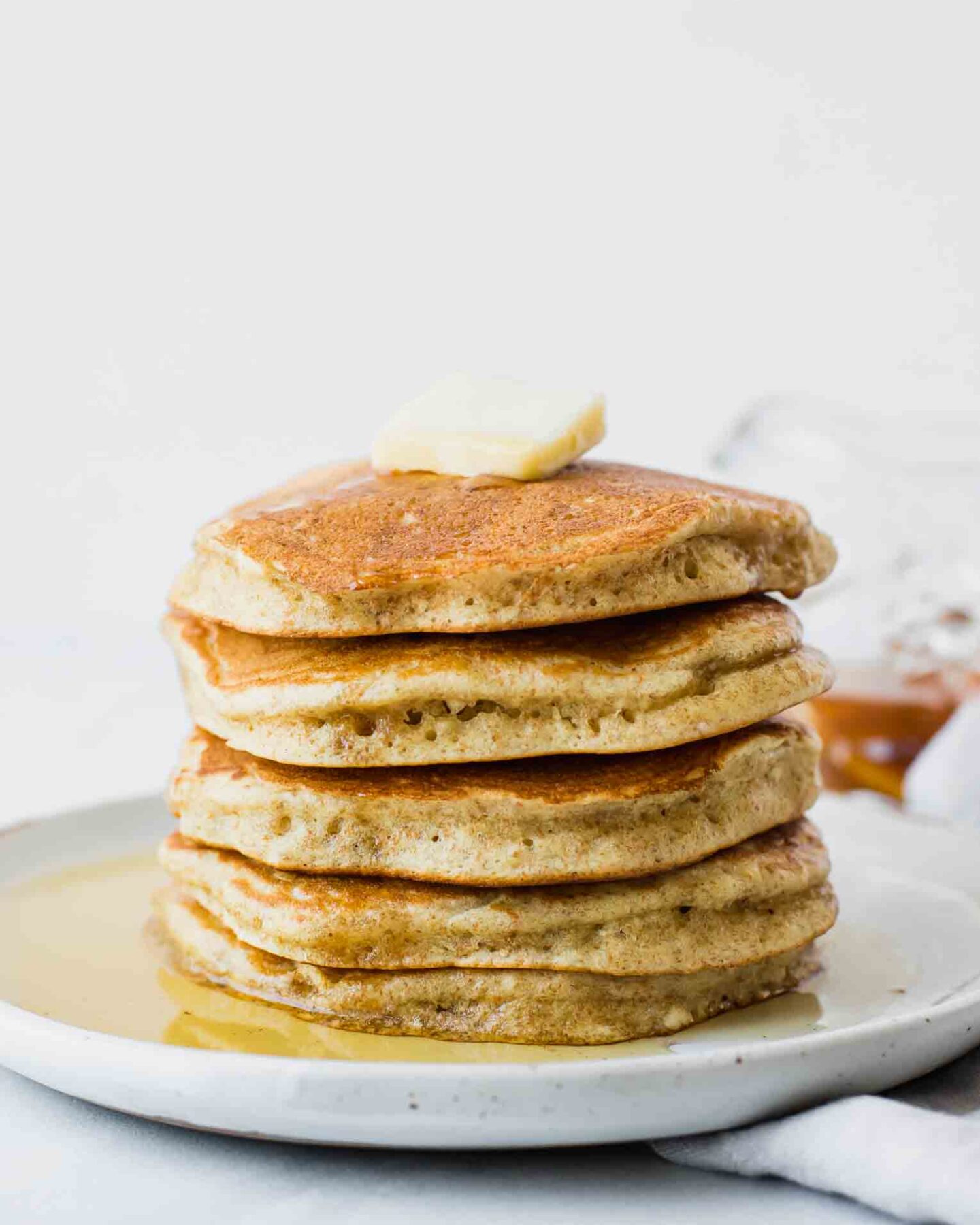 Fluffy sourdough pancakes topped with butter and syrup.