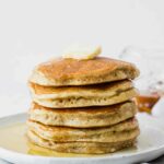 Fluffy sourdough pancakes topped with butter and syrup.