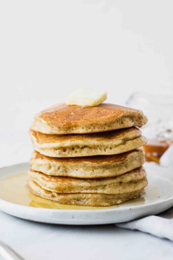 Fluffy sourdough pancakes topped with butter and syrup.