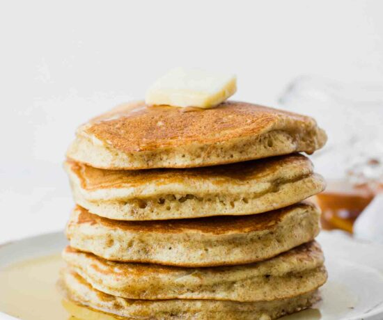 Fluffy sourdough pancakes topped with butter and syrup.