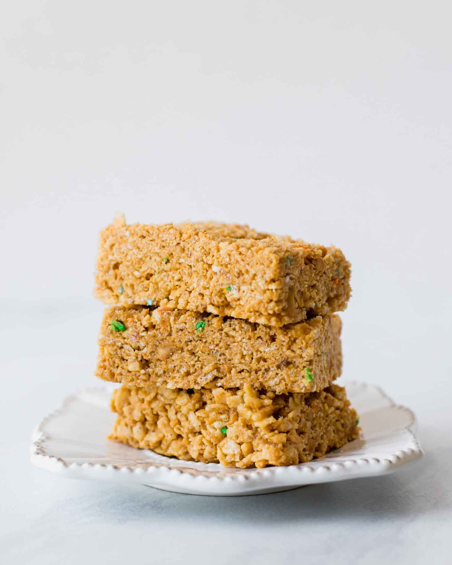 Across shot of healthy rice krispie treats stacked on a plate.