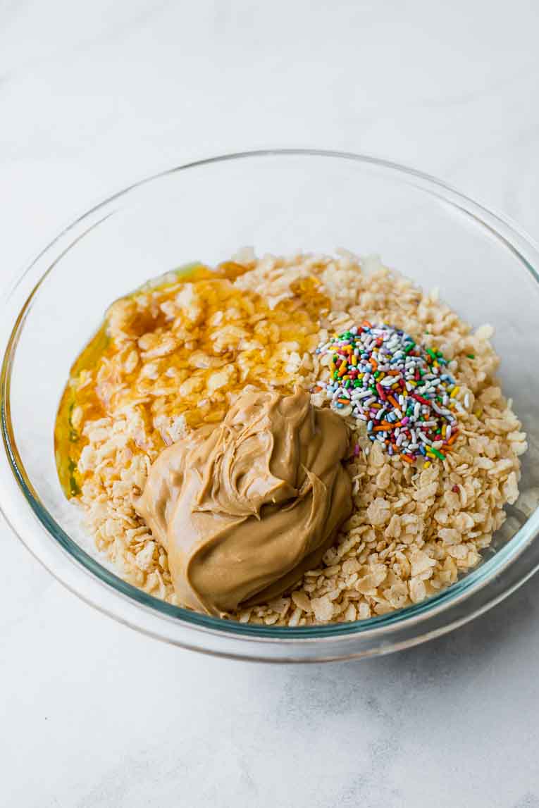 Ingredients for healthy rice krispie treats in a large mixing bowl.