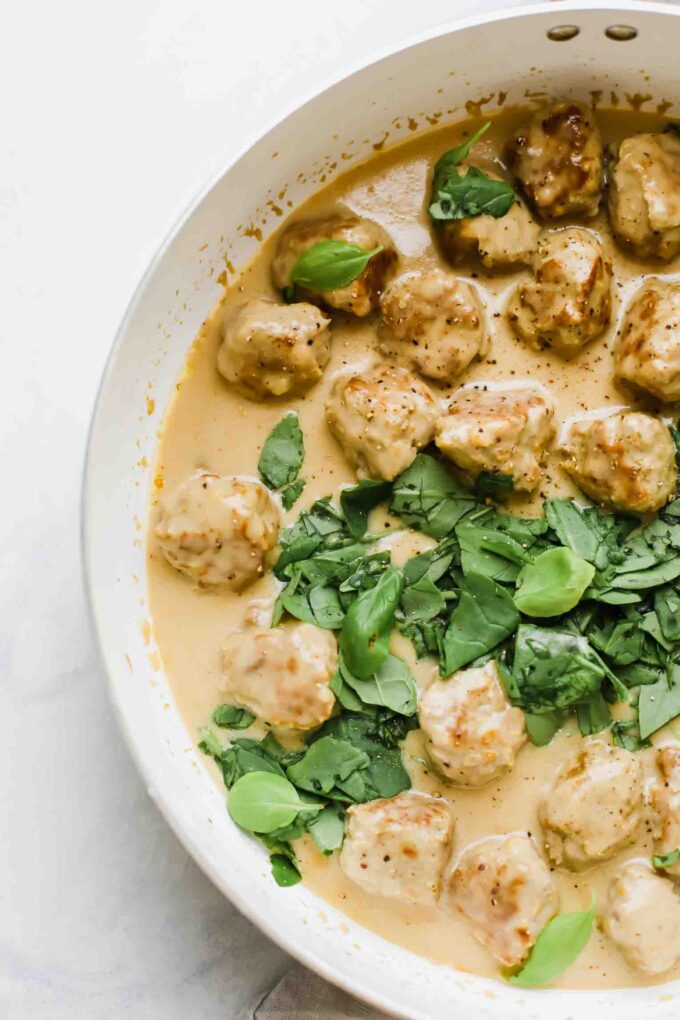 Close up of Swedish meatballs in a saucepan with gravy.