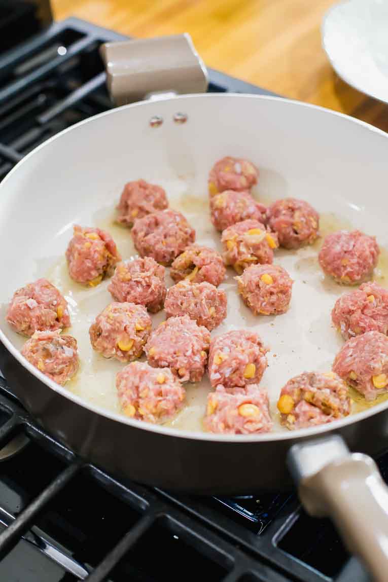 Turkey meatballs being cooked in a saucepan.