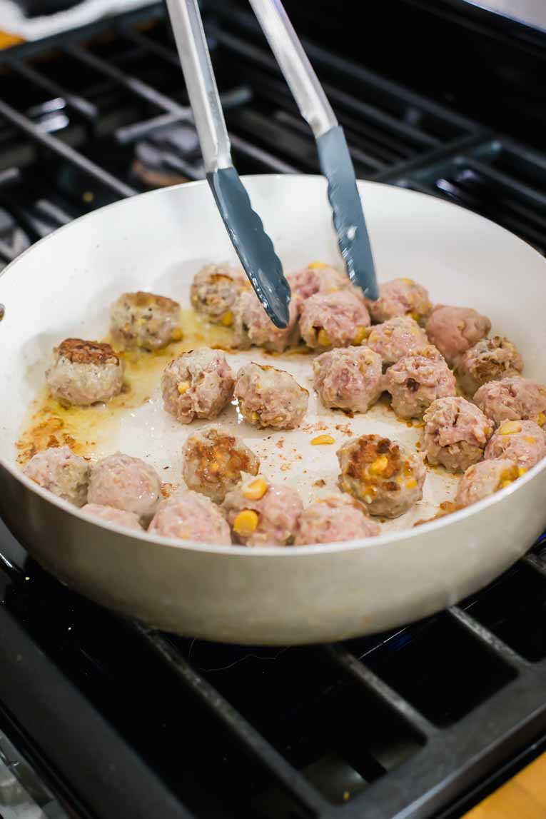 Turkey Swedish Meatballs being flipped over as they cook.