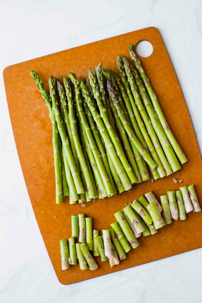 Asparagus with ends being cut off.