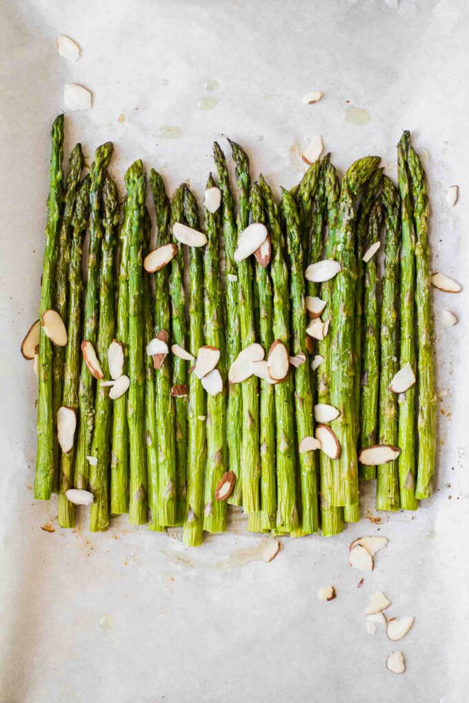 Close up of perfectly roasted asparagus on parchment paper.