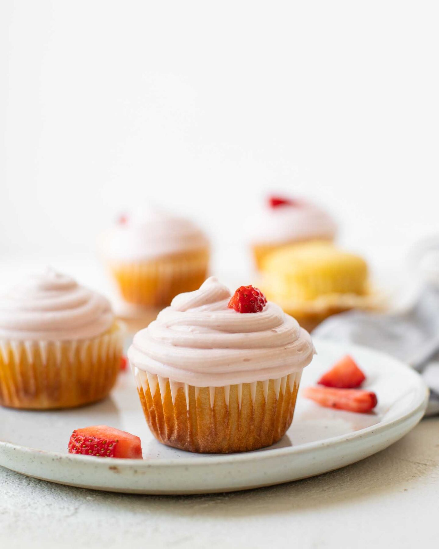 Across shot of Strawberry Lemonade Cupcakes on a white plate.