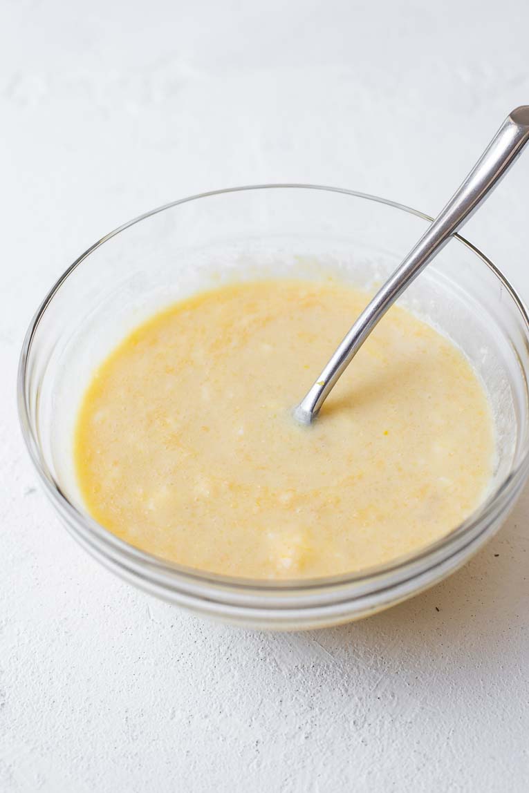 Liquid ingredients for lemon cupcakes in a glass mixing bowl.