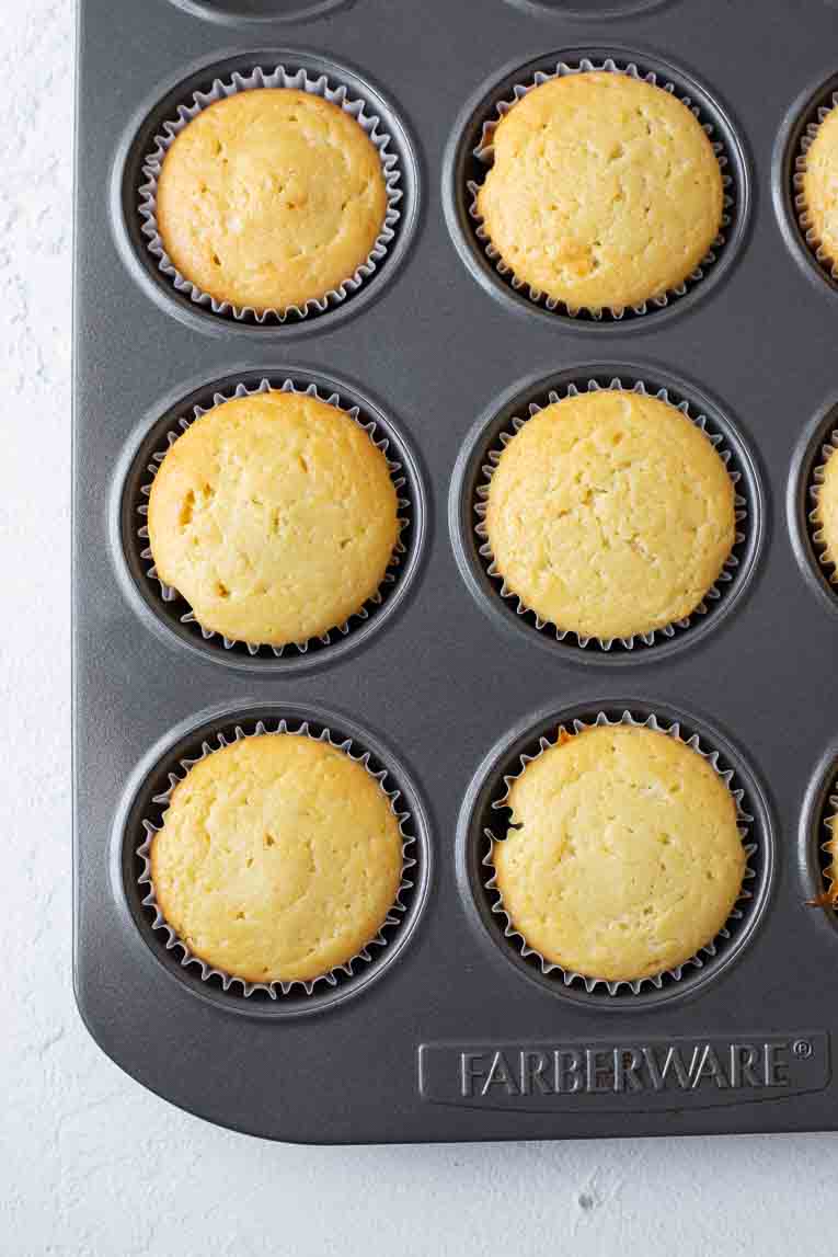 Baked lemon cupcakes in a cupcake pan.
