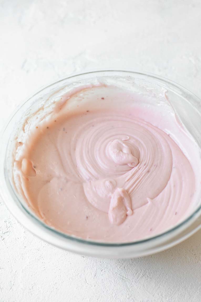 Strawberry cream cheese icing in a glass bowl.