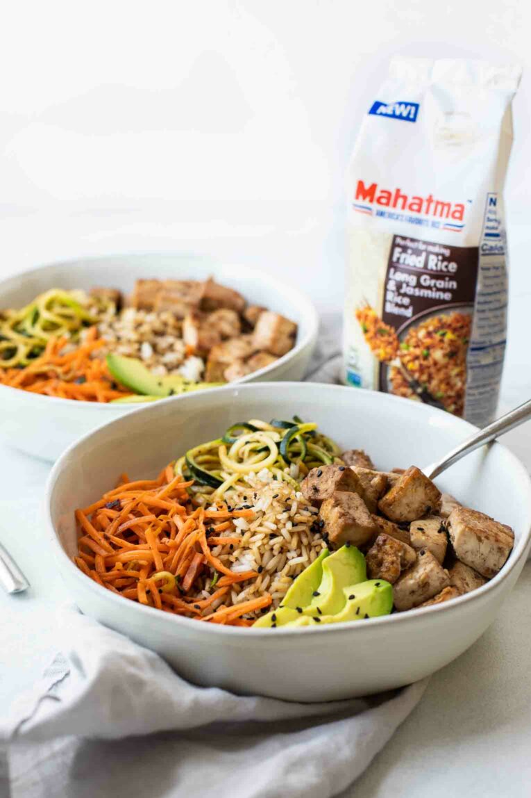 Angled shot of Asian Tofu Rice Bowl with fried rice in the background.