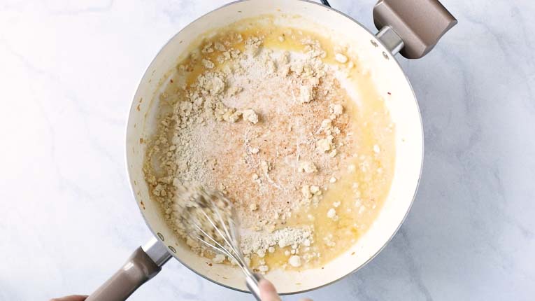 Butter and almond flour being cooked in a pan.