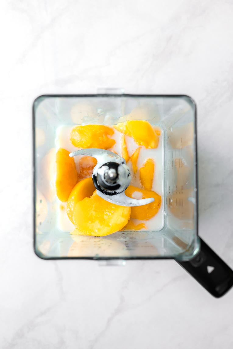 Peaches, yogurt, milk, and honey in a blender.