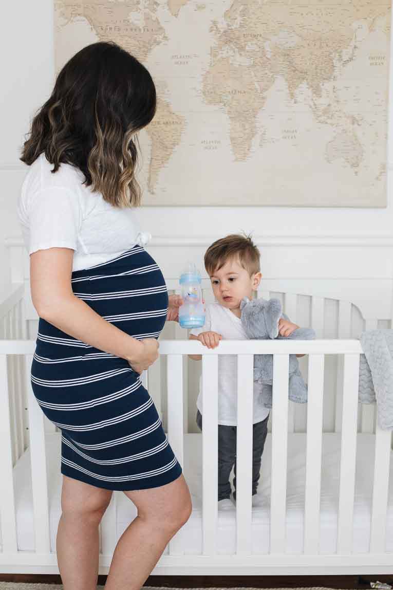 Mother next to toddler in his crib.