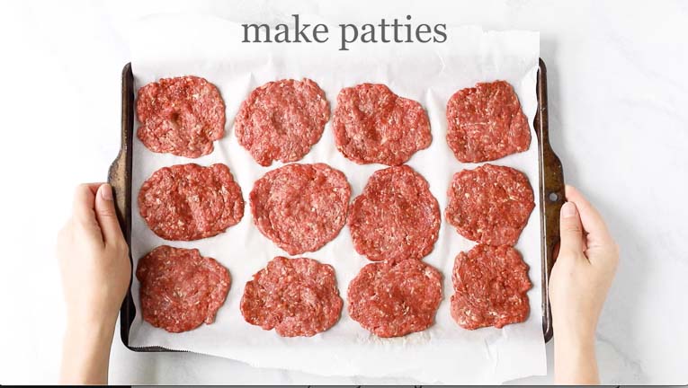 Burger patties on white parchment paper.