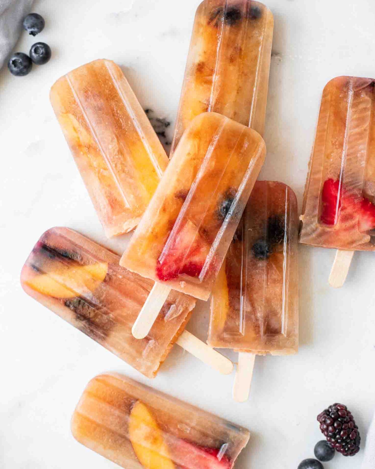 Close up of Lemon Sweet Tea Popsicles with blueberries, strawberries, and peaches.