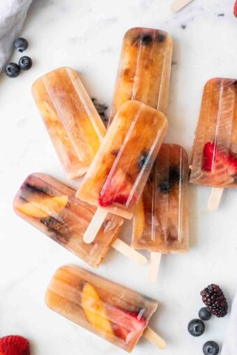 Close up of Lemon Sweet Tea Popsicles with blueberries, strawberries, and peaches.