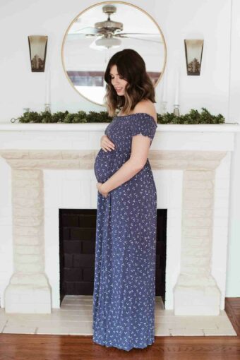 Pregnant woman in her third trimester holding her bump.