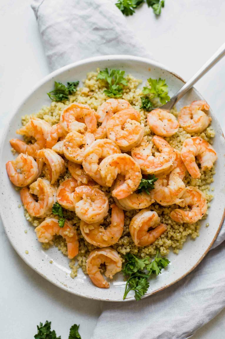 Easy Lemon Garlic Shrimp with quinoa on a white plate.