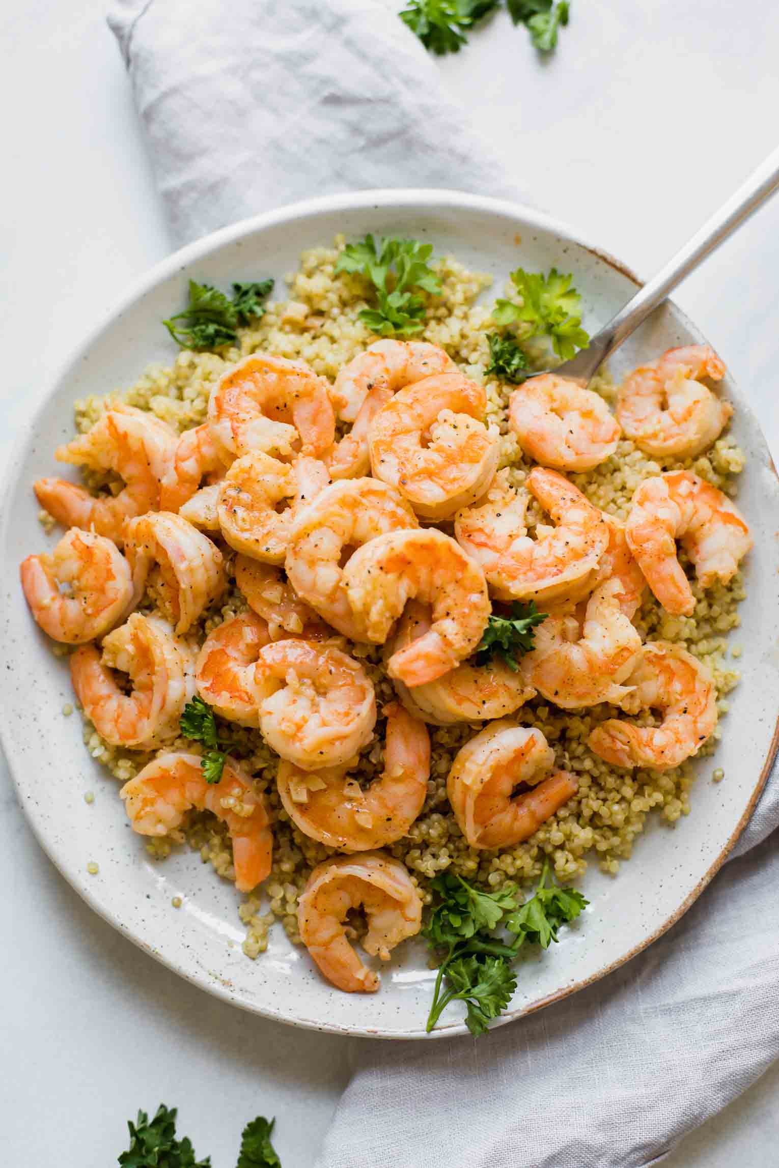 Easy Lemon Garlic Shrimp with quinoa on a white plate.