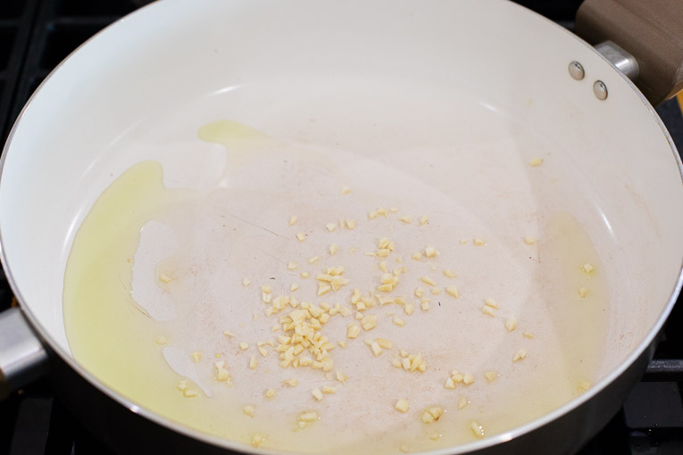 Oil and garlic cooking in a sauce pan.