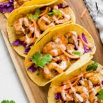 Top shot of Sriracha Lime Shrimp Tacos on a brown cutting board.