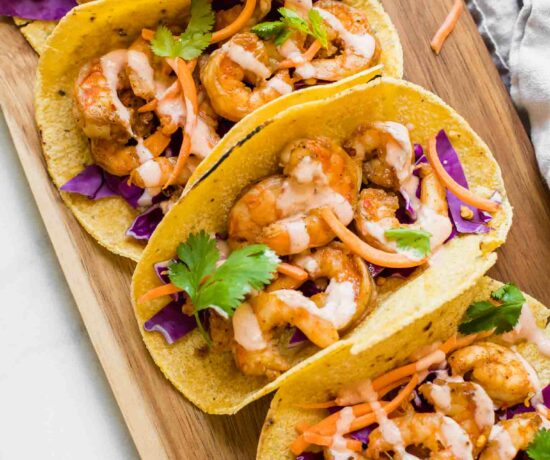 Top shot of Sriracha Lime Shrimp Tacos on a brown cutting board.