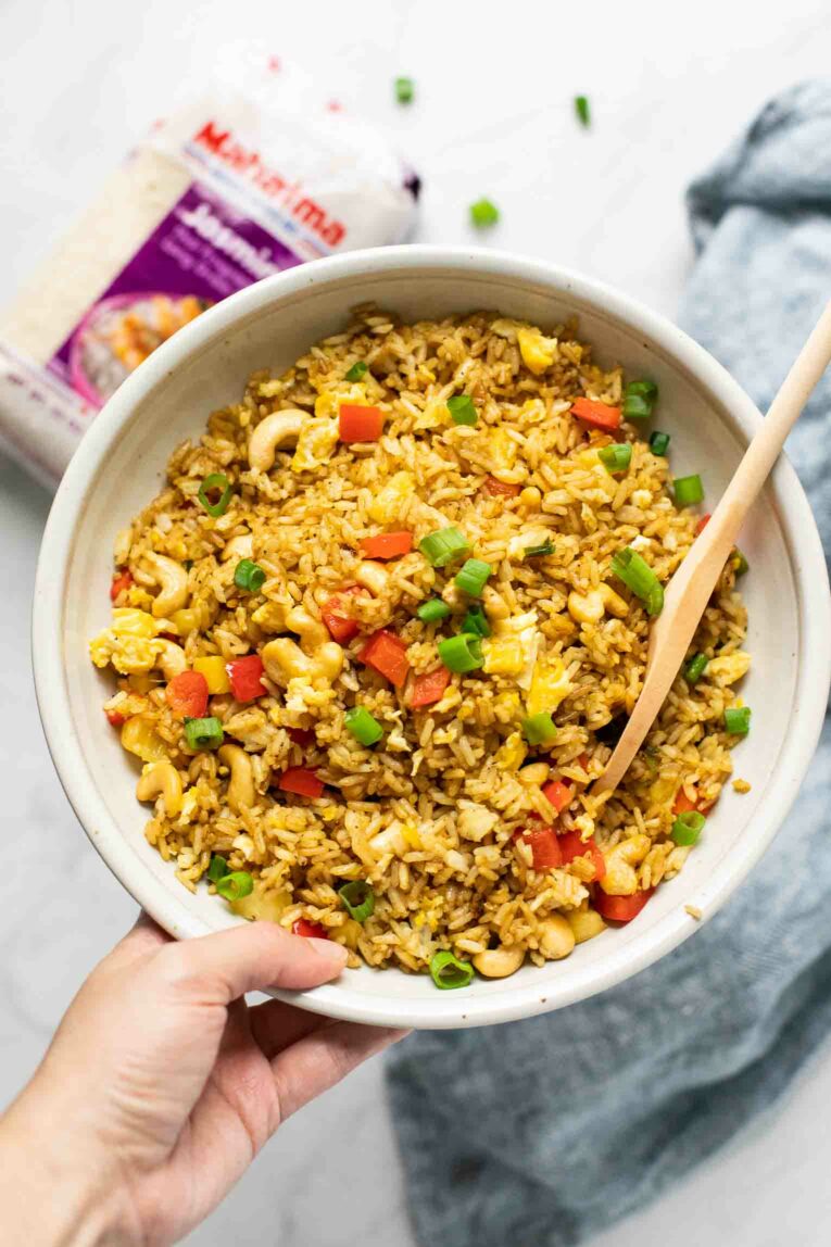 Hand holding bowl of Thai Pineapple Fried Rice.