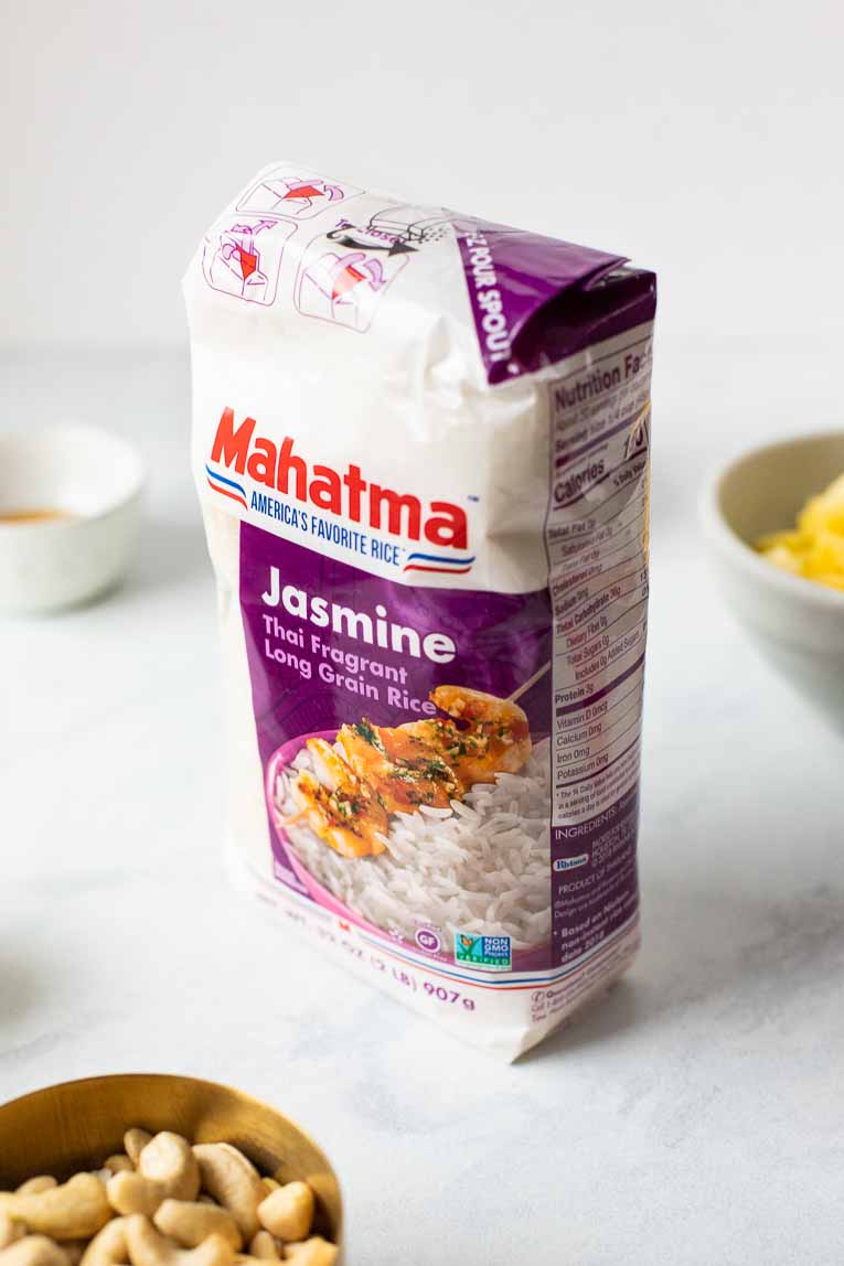 Mahatma Jasmine Rice on a white table with ingredients in the background.