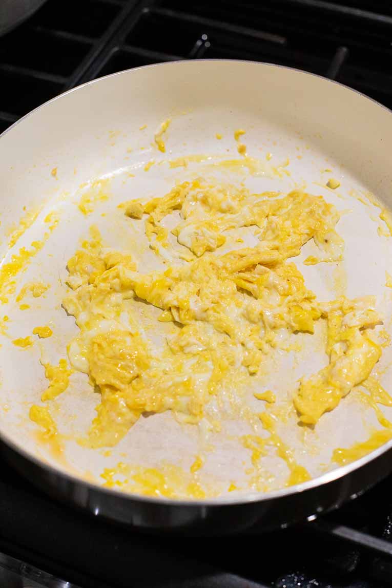 Eggs being scrambled in a skillet.
