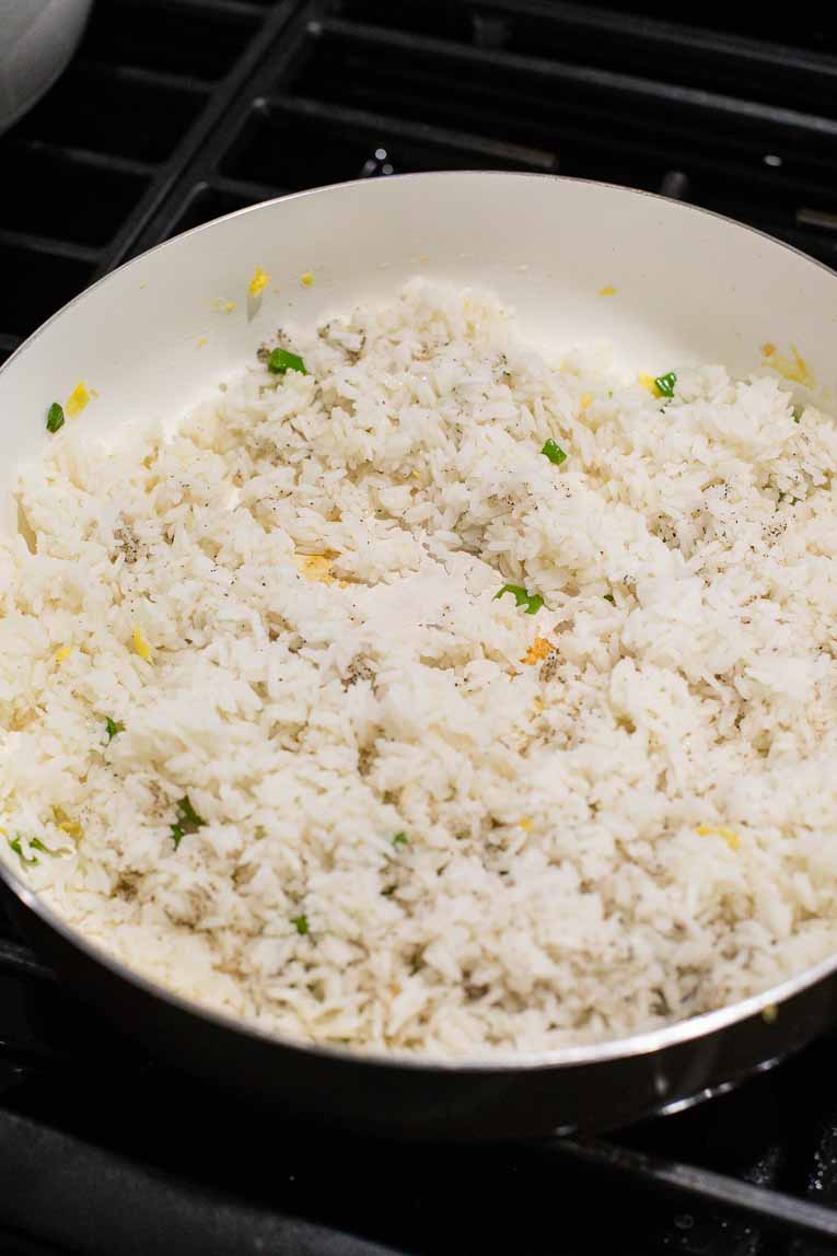 Jasmine rice with green onions in a skillet.