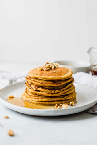 Stack of Healthy Sweet Potato Pancakes on a white plate.