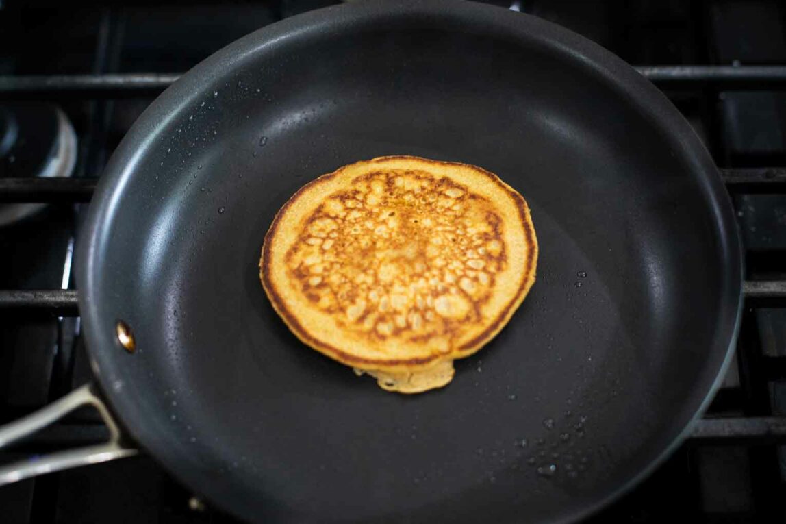 Sweet potato pancake being cooked in a pan.