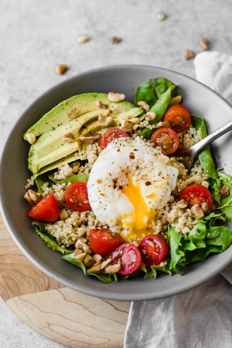 Poached egg running over a healthy breakfast salad.