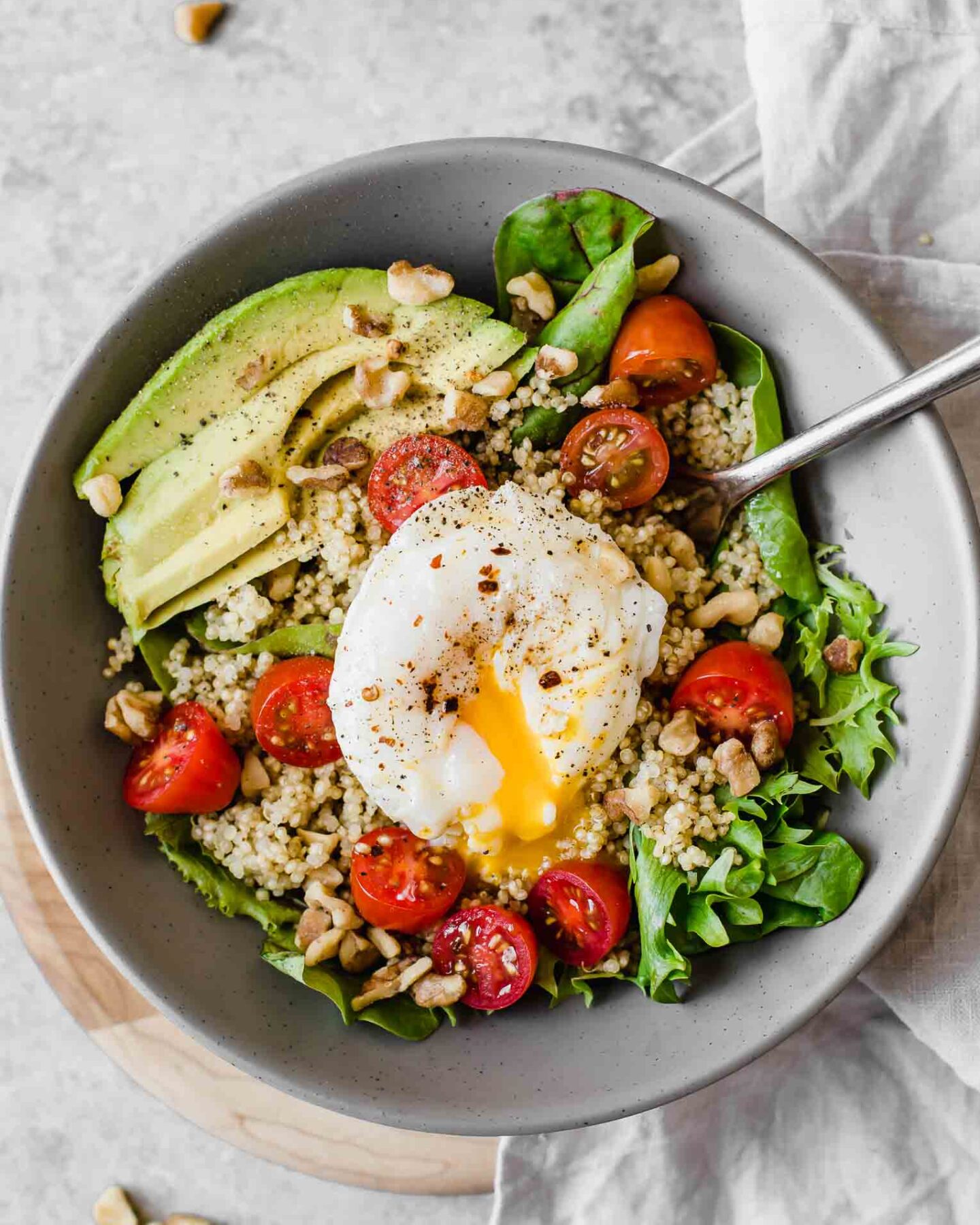 Close up of Poached Egg & Avocado Breakfast Salad in a grey bowl.