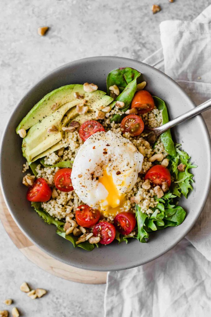 Close up of Poached Egg & Avocado Breakfast Salad in a grey bowl.
